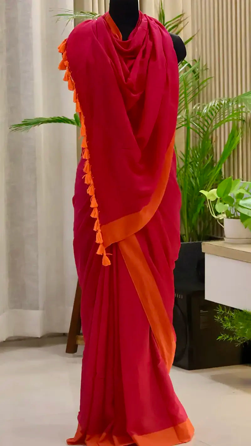 Red and orange saree with tassels on a mannequin against a neutral background