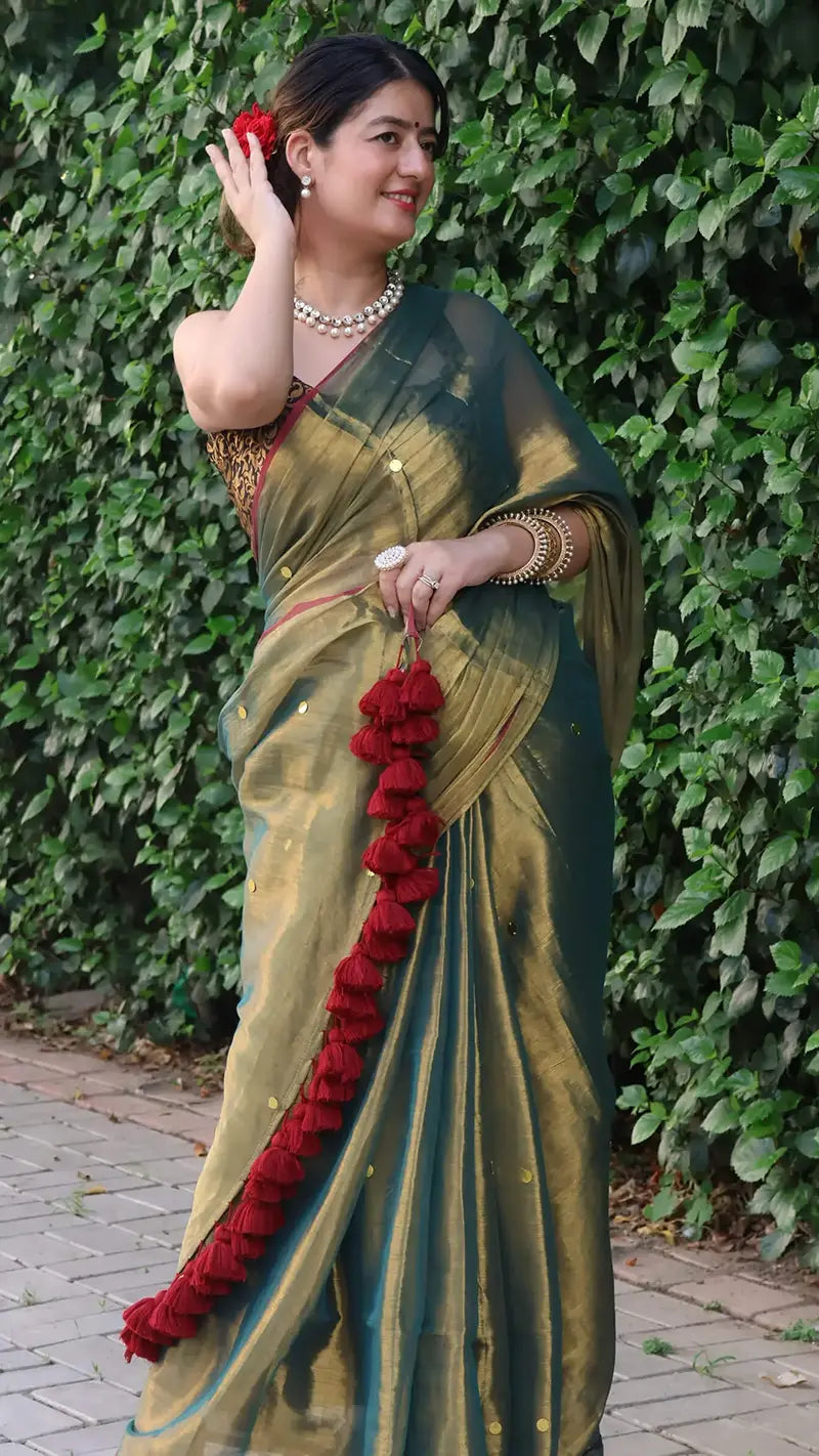 Woman in a Museli Gold Elegant Tissue Saree against a leafy background