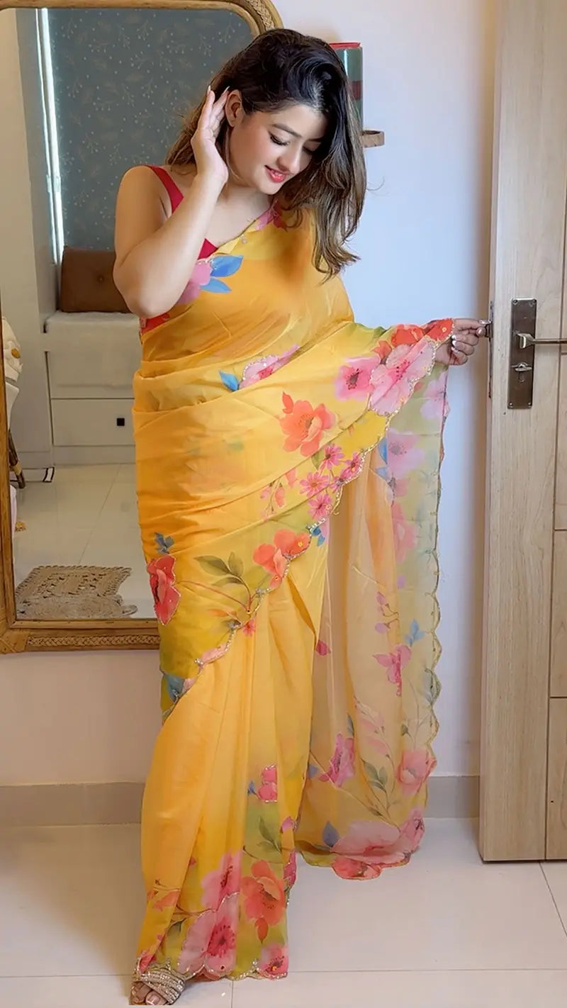 Woman wearing a yellow floral saree in a room.