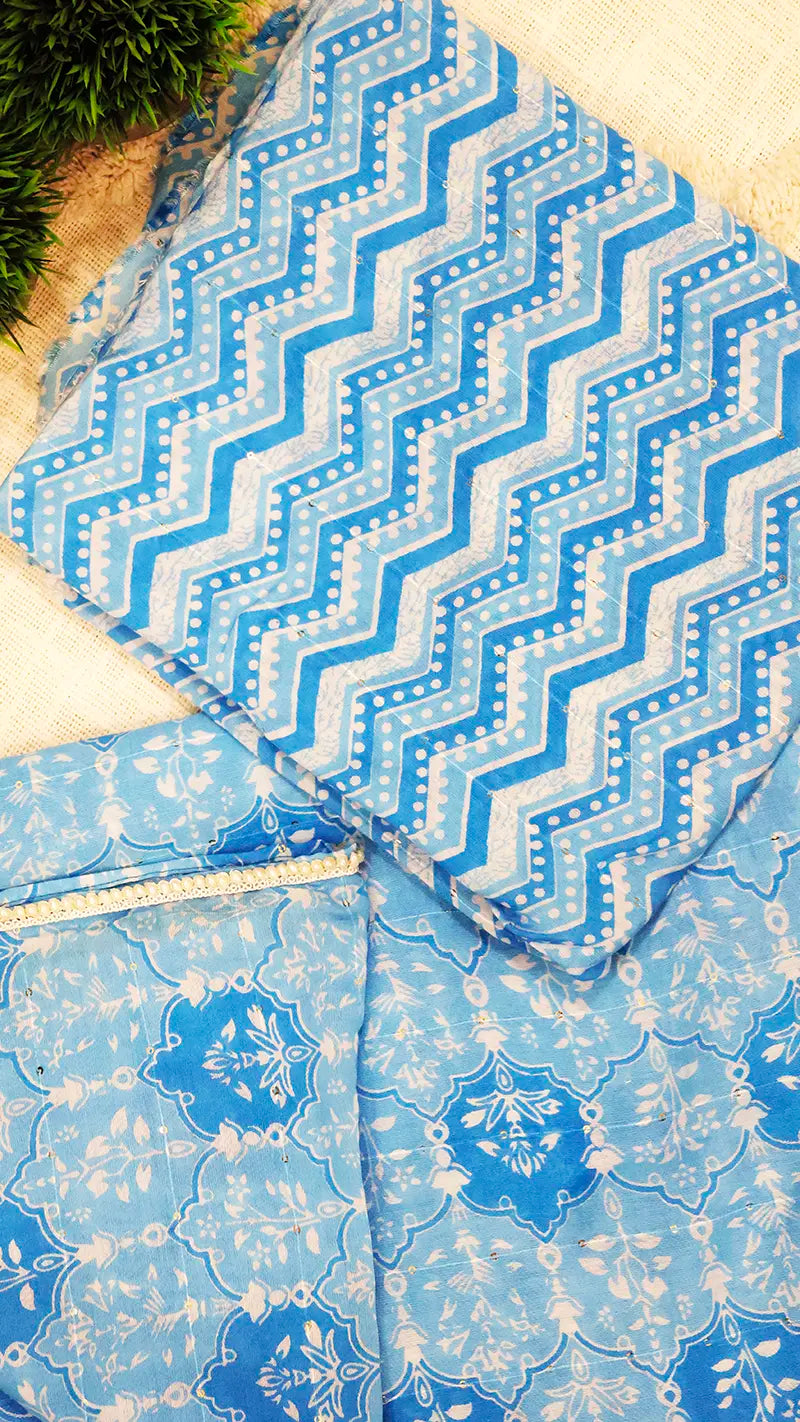 Blue and white patterned blouse piece with zigzag design on a beige surface