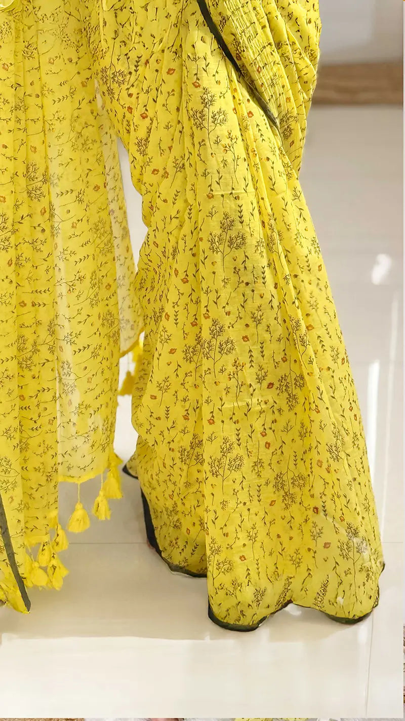 Yellow floral saree with tassels on a white background