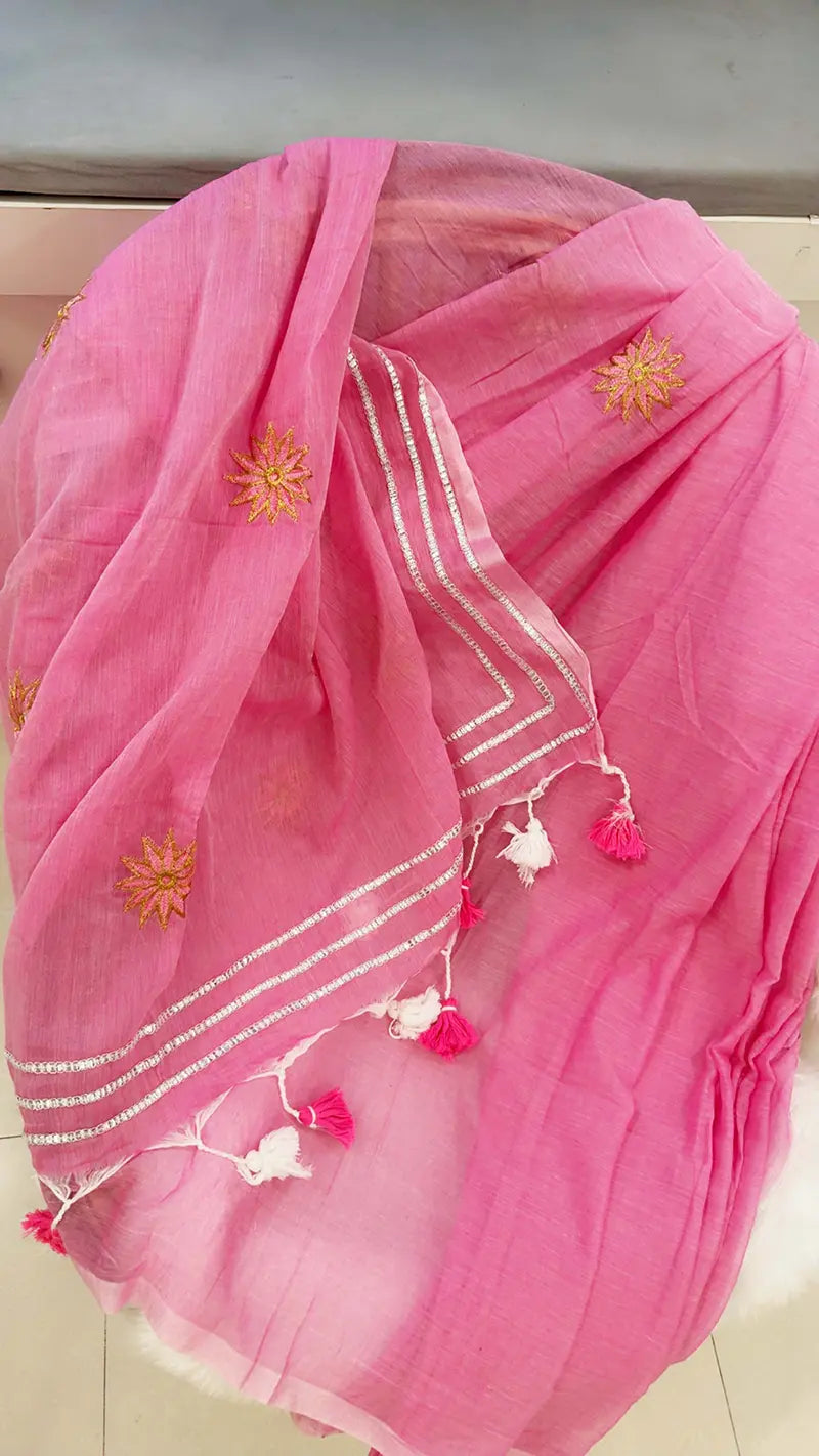 Pink saree with floral embroidery and tassels on a light background