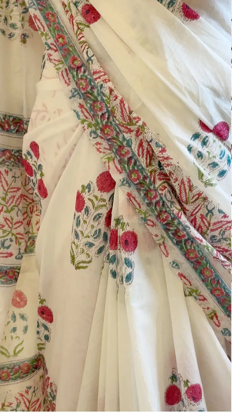 Close-up of a white saree with colorful floral patterns