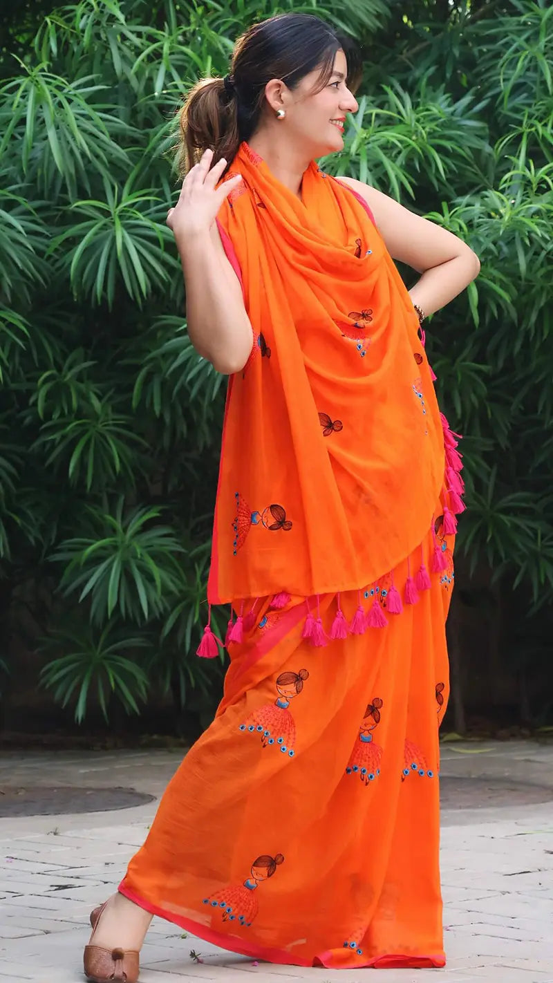 Woman wearing an orange saree with a green leafy background