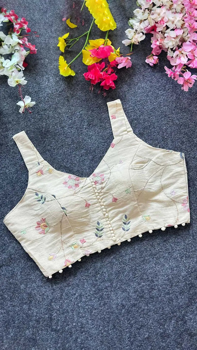 Floral embroidered blouse on a dark surface with flowers around