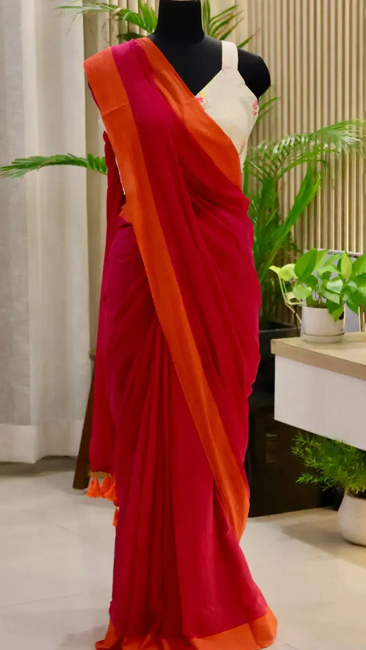 Red saree with orange border on a mannequin against a neutral background