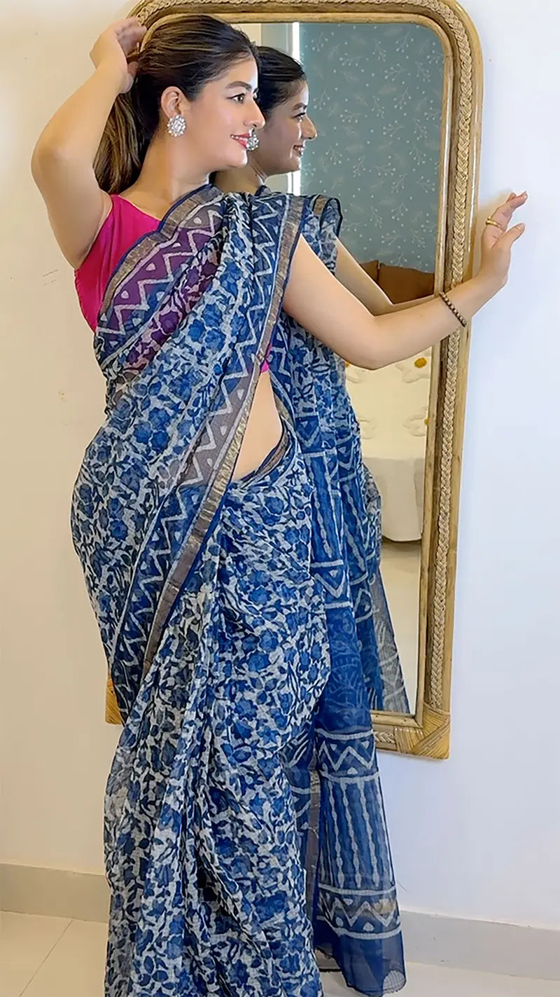 Woman in a blue saree with a mirror reflection in the background